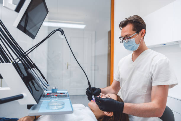 istock Dentist Performing Procedure in Modern Clinic 2165936349