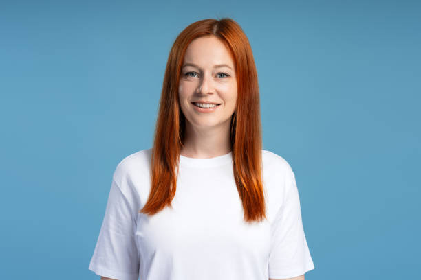istock Beautiful, smiling, red head woman posing on blue background 2165937159