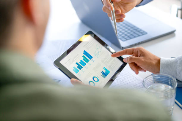 istock Three  business men meeting and looking at financial data, charts and graphs on a digital tablet and a laptop computer. T 2165937993