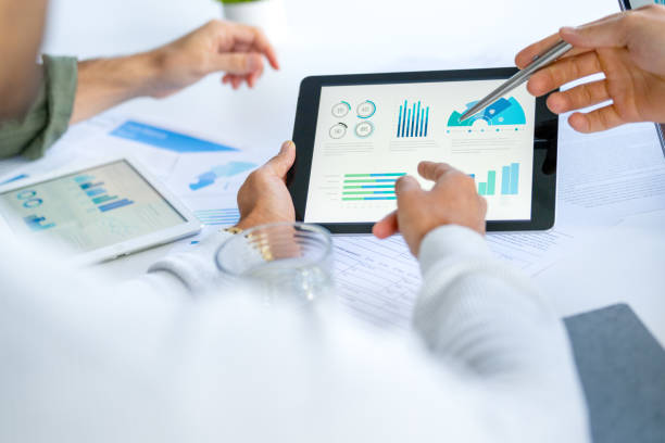 istock Three  business men meeting and looking at financial data, charts and graphs on a digital tablet and a laptop computer 2165938002