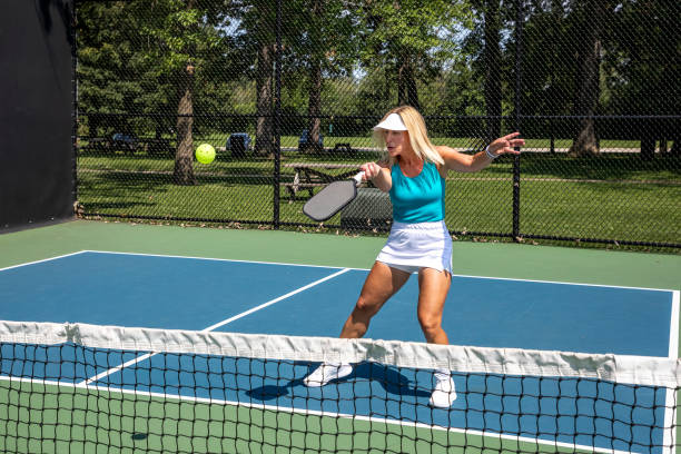 istock Female pickleball player returns ball at net 2165939541
