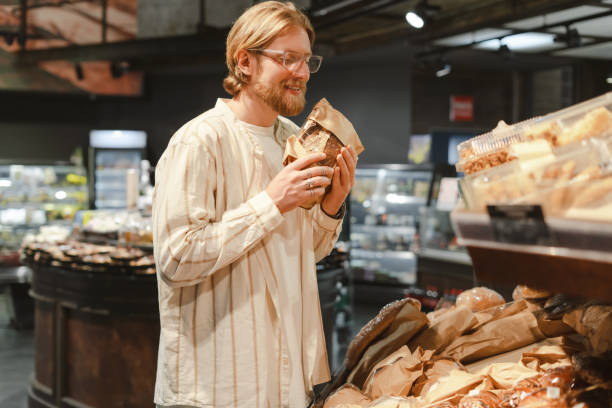 istock Smiling customer choosing bread in grocery store bakery 2165941162