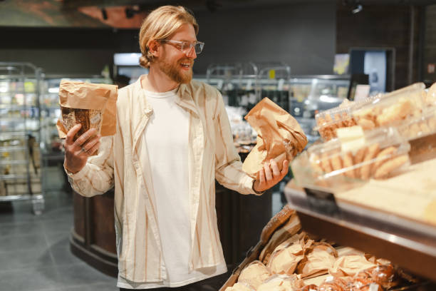 istock Smiling man choosing bread in a grocery store bakery 2165941168