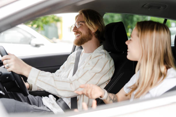 istock Young couple driving in car having fun conversation 2165941187