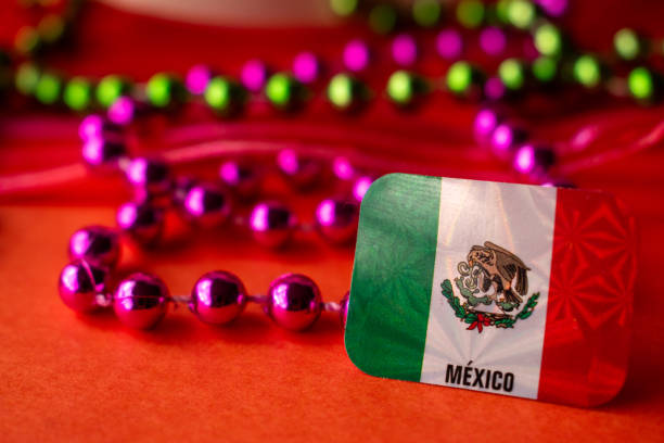 High angle view of Mexican flag and colorful carnival stuff on orange color background