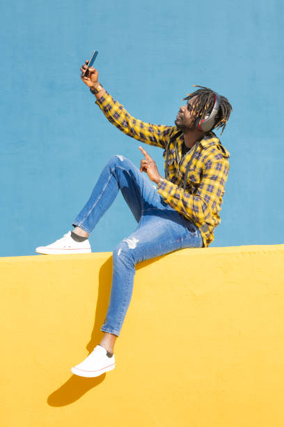 istock black man with headphones making a video call 2165944365