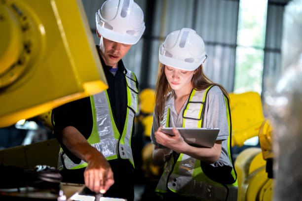 istock team engineers inspecting on machine with smart tablet. Worker works at heavy machine robot arm. The welding machine with a remote system in an industrial factory. Artificial intelligence concept. 2165946135