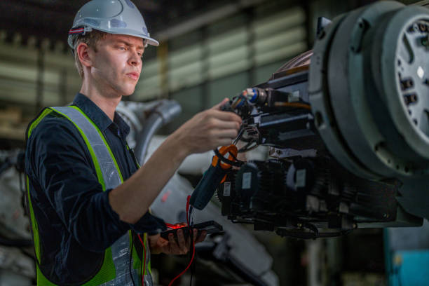 istock male engineer workers maintenance automatic robotic arm machine in a factory. worker checking and repairing automatic robot hand machine. technician worker check for repair factory machine. 2165948070