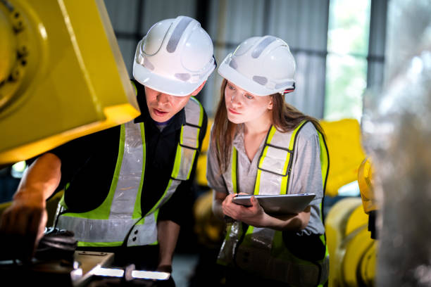 istock team engineers inspecting on machine with smart tablet. Worker works at heavy machine robot arm. The welding machine with a remote system in an industrial factory. Artificial intelligence concept. 2165948968