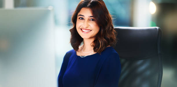 istock Smile, portrait and Indian woman in office with computer, commitment and confidence for project. Bokeh, happy and professional employee in workplace for planning, research and business administration 2165949098