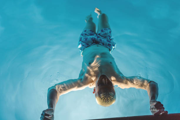 istock Fit Male Relaxing in Swimming Pool 2165949713