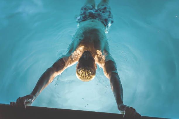 istock Fit Male Relaxing in Swimming Pool 2165949714