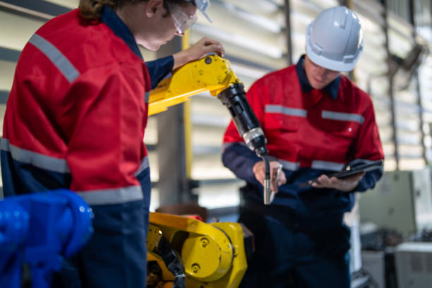 istock male engineer workers maintenance automatic robotic arm machine in a factory. worker checking and repairing automatic robot hand machine. technician worker check for repair factory machine. 2165950013