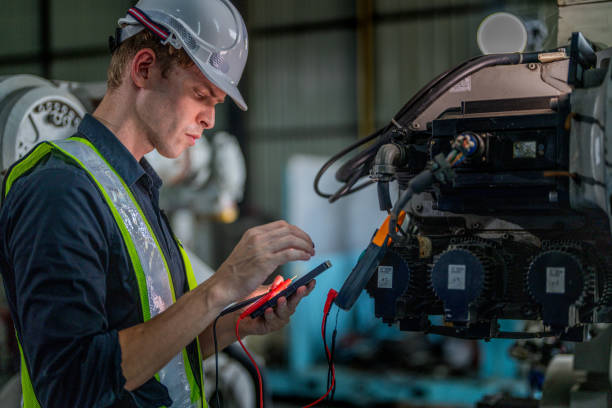 istock male engineer workers maintenance automatic robotic arm machine in a factory. worker checking and repairing automatic robot hand machine. technician worker check for repair factory machine. 2165950197