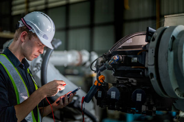 istock male engineer workers maintenance automatic robotic arm machine in a factory. worker checking and repairing automatic robot hand machine. technician worker check for repair factory machine. 2165950479