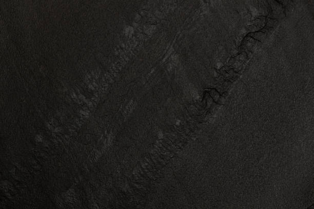 Dark grey black slate texture in natural pattern with high resolution for background and design artwork. Uneven rough stone surface, height differences. Abstract pattern close-up, top view