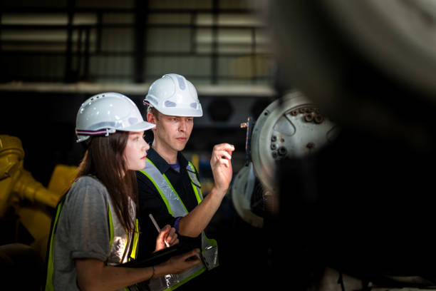 istock Factory engineers inspect on machine. Confident team mature businessman with laptop standing by robotic arm in industry businessman inspect at height technology for produce the electronic part device. 2165951240