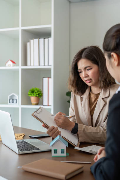 istock Professional Real Estate Agent Discussing Property Details with Client in Modern Office Setting 2165953190