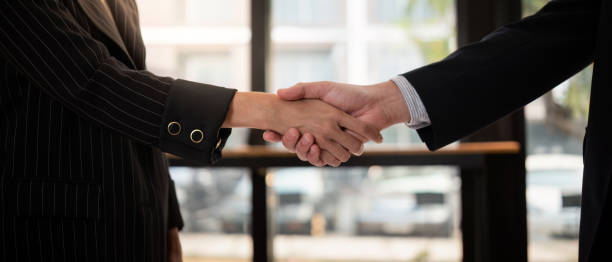 istock Professional Business Handshake Between Two Individuals in Formal Attire in a Modern Office Setting 2165953806
