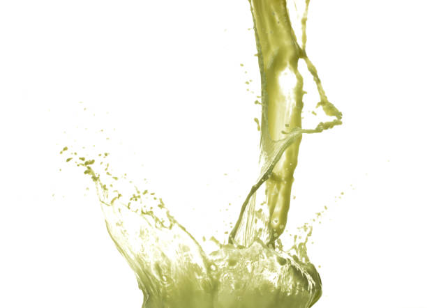 A glass with a foamy yellow and green cocktail on a white background, foam in a glass