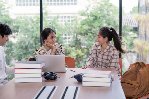 istock Group of Student Studying Together in a Modern Library with Laptops and Books 2165954449