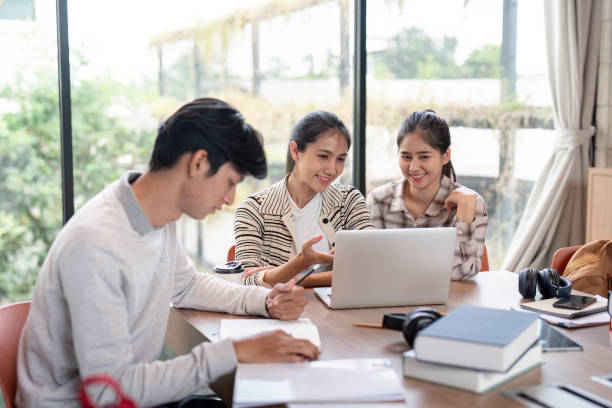 istock Group of Student Collaboration on a Project in a Modern Study Space with Laptops and Books 2165954502
