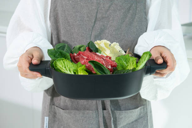 istock holding a pot of cooking ingredients. 2165955005