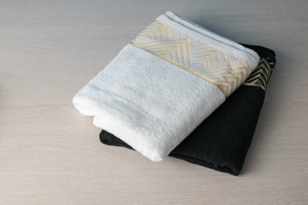 istock Folded White and Black Towels with Geometric Patterns on Wooden Table 2165956309