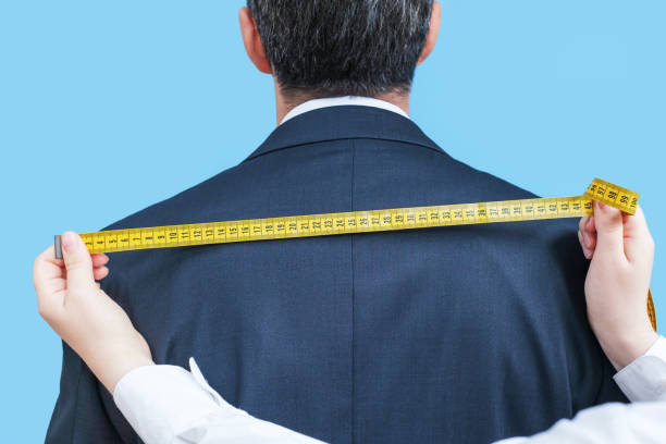 istock The tailor measures the suit with a measuring tape close-up, back view. 2165958228