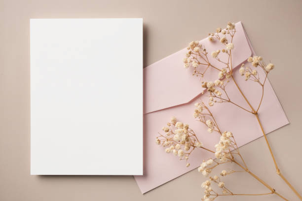 istock White blank greeting or invitation card and envelope with ceramic jar decoration on beige background. Mock up presentation. Flat lay. 2165962286