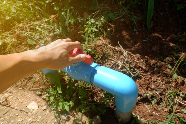 istock Man's hands adjusting the turn of a large plastic water valve. 2165966449