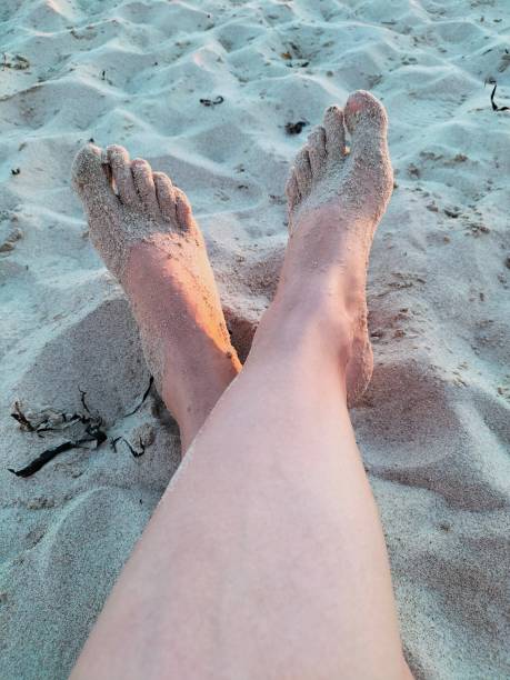 istock Bare feet in sand 2165966750
