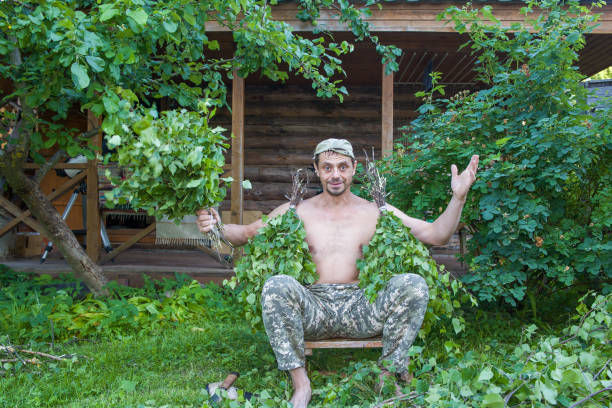 A village man makes birch brooms for a bathhouse.
