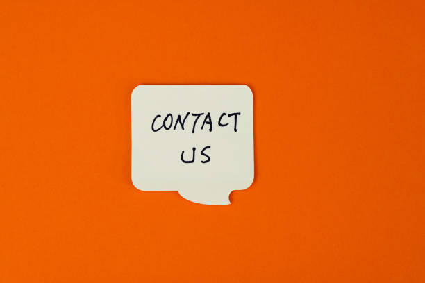 Yellow adhesive note with text contact us on orange background.