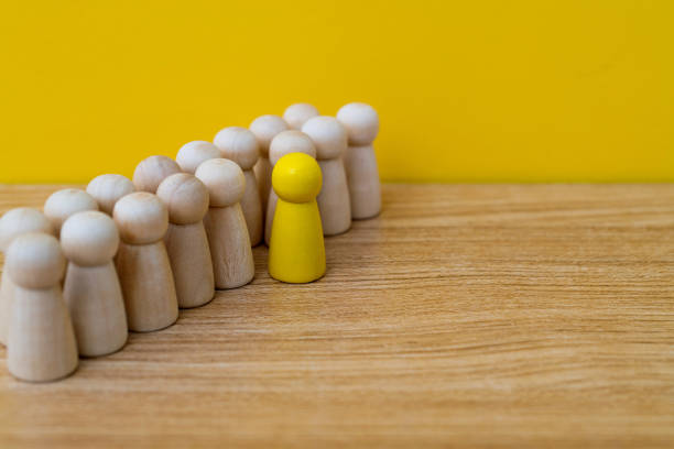 istock Yellow one standing out from the wooden figures 2165969244