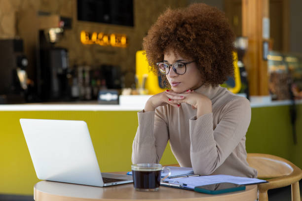 istock Woman using laptop and making notes, sitting at desk at cafe 2165974042