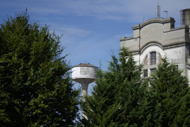 Vukovar, Croatia, November 1st, 2024: The abandoned Hotel Dunav stands beside the historic yellow water tower, symbolizing resilience and heritage.