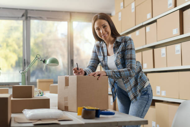 istock E-commerce owner writing an address on a delivery box 2165977838