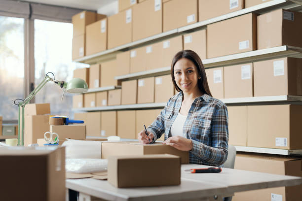 istock E-commerce owner writing an address on a delivery box 2165978070