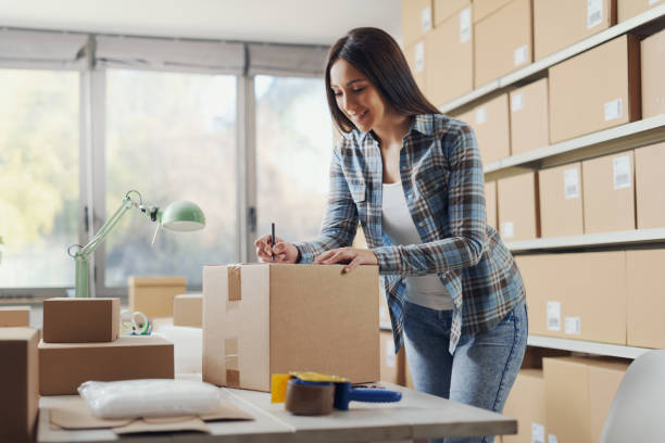 istock E-commerce owner writing an address on a delivery box 2165978299