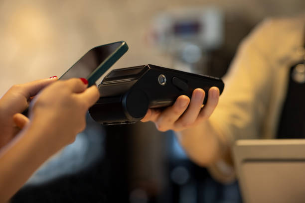 istock Female hand paying with phone app on POS machine. 2165978608