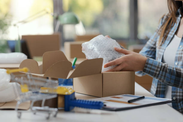 istock Woman putting goods in a delivery box 2165978612
