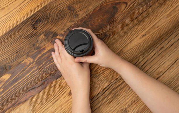 istock Hand Holds Cup, Empty Paper Cup in Hands, Coffee Mug, Teacup, Hot Beverage Mockup, Cup in Arms 2165982419