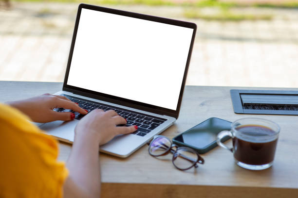 Mockup image of a woman using and typing on laptop computer with blank white desktop screen in cafe