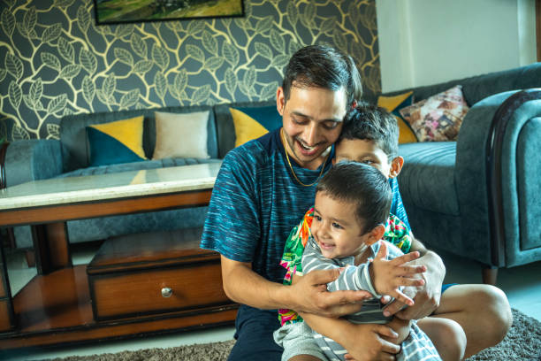 istock Cheerful father playing with sons at home 2165983379