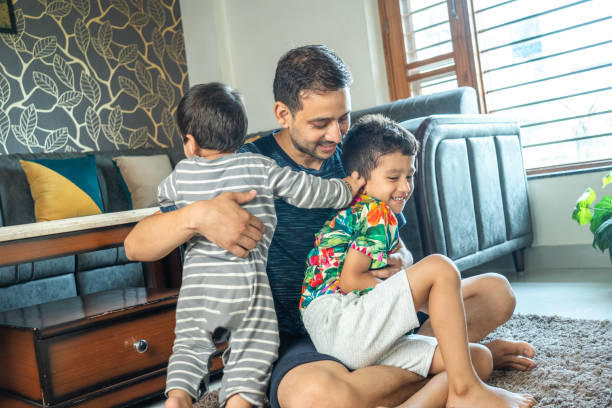 istock Cheerful father playing with sons at home 2165983463