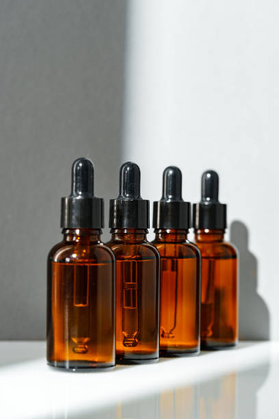 istock Four Amber Glass Bottles With Dropper Tops on White Surface 2165983661