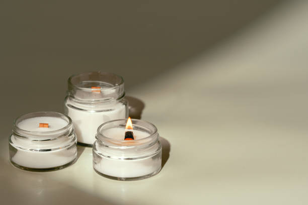 istock Candles in Glass Jars on a Light Beige Surface 2165984027