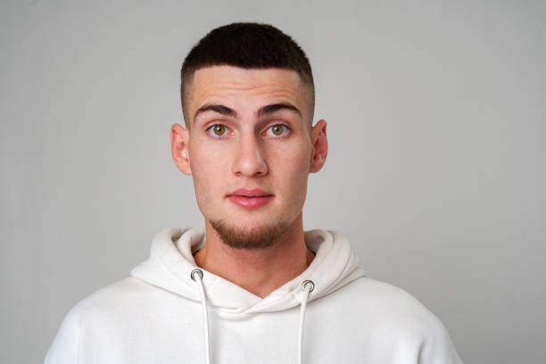 istock Young Man Looking Surprised Against a Gray Background 2165986421