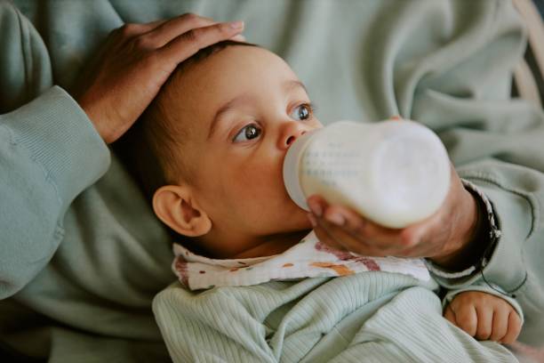 istock Baby Eating while His Mother Patting Him 2165987482